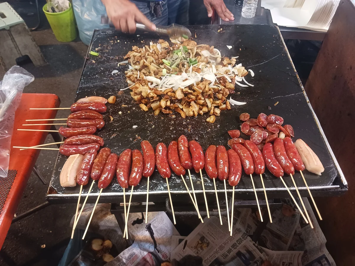 烤盤上刷醬的香腸與串燒