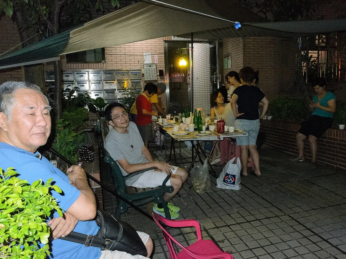 中秋夜巷子裡的烤肉聚會,烤網上同時放著肉與蔬菜